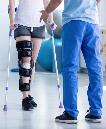 Patient recovering after surgery, performing gentle leg exercises with therapist guidance during post-op rehabilitation session